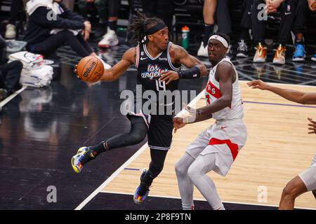 Der Los Angeles Clippers Guard Terance Mann (L) sieht beim Pass zu, während er von Toronto Raptors Forward Pascal Siakam (R) während eines NBA-Basketballspiels in der Crypto.com Arena in Los Angeles am Dienstag, den 8. März 2023 verteidigt wird. Stockfoto