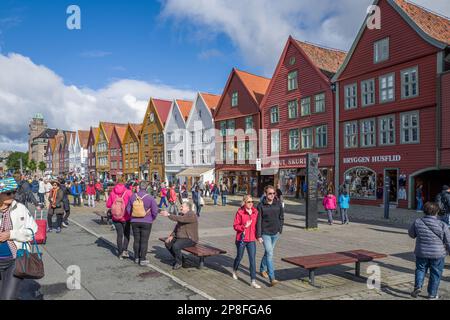 Touristen genießen Norways Meistbesuchte Touristenattraktion Bryggen. Bryggen ist eine Reihe alter hanseatischer Geschäftsgebäude und gehört zum UNESCO-Weltkulturerbe Stockfoto