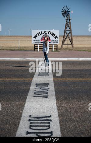 Ein abenteuerlustiges, blondes Mädchen in der Mitte der Route 66 Stockfoto