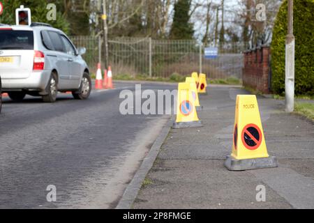 Die Polizei-Verkehrskegel auf dem Bürgersteig verhindern, dass Leute parken, wenn sie Kinder von der Schule Belfast Northern Ireland UK abholen Stockfoto