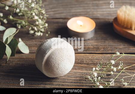 Spa-Komposition mit Badebombe, Kerze und getrockneten Blumen. Stockfoto