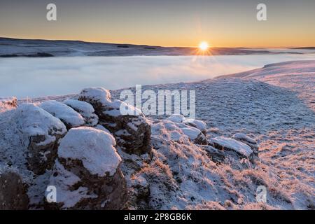 Dramatischer Sonnenaufgang im Winter, während der Nebel das Tal von Upper-Wharfedale über dem Dorf Kettlewell im Yorkshire Dales National Park, Großbritannien, füllt Stockfoto