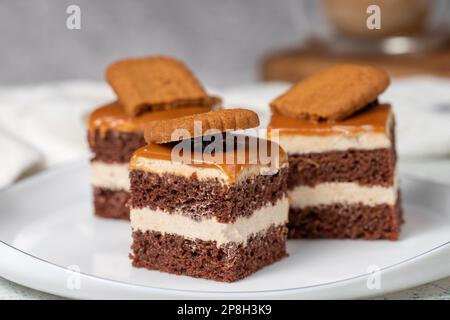 Kleine Dessertkuchen. Karamell Petit 4 auf einem weißen Teller mit dunklem Hintergrund. Keks, französischer Petit, vier Kuchen. Schließen Stockfoto