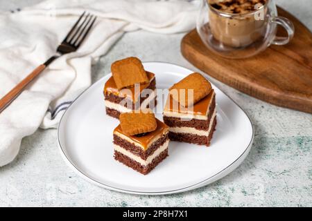 Kleine Dessertkuchen. Karamell Petit 4 auf einem weißen Teller mit dunklem Hintergrund. Keks, französischer Petit, vier Kuchen Stockfoto