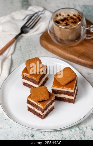 Kleine Dessertkuchen. Karamell Petit 4 auf einem weißen Teller mit dunklem Hintergrund. Keks, französischer Petit, vier Kuchen Stockfoto