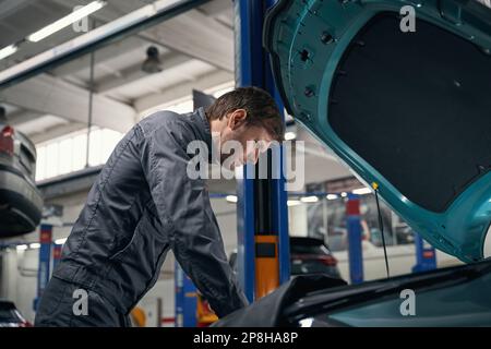 Männlich führt eine vollständige technische Überprüfung des Autos durch Stockfoto