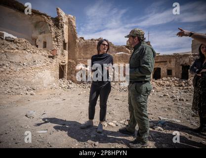 Sindschar, Irak. 09. März 2023. Annalena Baerbock (Bündnis 90/die Grünen, l), Außenministerin, spricht mit Ian Johnston von Global Clearance Solutions, der für die Minenräumung im zerstörten Stadtzentrum von Sinjar zuständig ist. Während ihrer Reise besucht Baerbock die nordirakische Stadt Sinjar, die wichtigste Siedlungsregion der Yazidis. Der Islamische Staat gilt als verantwortlich für den Völkermord an den Yazidis nach 2014. Kredit: Michael Kappeler/dpa/Alamy Live News Stockfoto