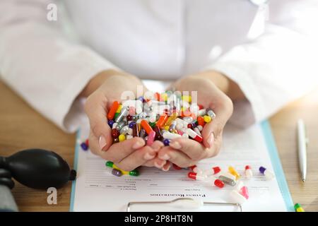 Eine Ärztin hält eine Reihe verschiedener medizinischer Pillen in ihren Händen. Stockfoto