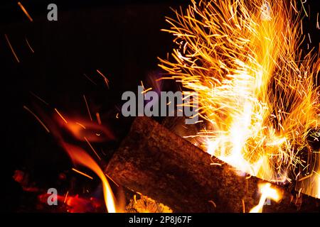 Funken fliegen von einem brennenden Holzfeuer Stockfoto