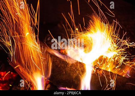 Funken fliegen von einem brennenden Holzfeuer Stockfoto