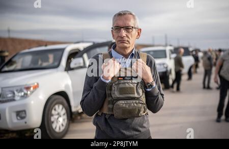 Sindschar, Irak. 09. März 2023. Martin Jäger, deutscher Botschafter im Irak, steht mit Schutzweste auf dem Konvoi des Außenministers Annalena Baerbock (Bündnis 90/die Grünen) auf dem Weg in das zerstörte Stadtzentrum von Sinjar. Baerbock besucht die nordirakische Stadt Sinjar, die wichtigste Siedlungszone der Yazidis. Der Islamische Staat gilt als verantwortlich für den Völkermord an den Yazidis nach 2014. Kredit: Michael Kappeler/dpa/Alamy Live News Stockfoto