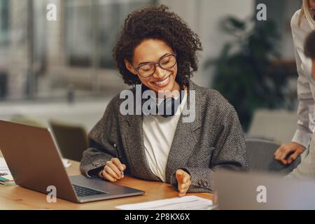 Frau Büroangestellte bespricht neues Projekt mit Kollegen während des Arbeitstages in der Zusammenarbeit Stockfoto