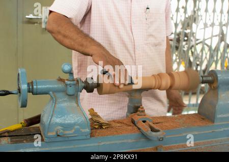 Person, die an einer Drehmaschine zum Drehen von Holz arbeitet, Indien Stockfoto