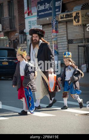 Die Kinder eines chassidischen Juden feiern Purim in Kostümen. Auf der Lee Avenue in Williamsburg, Brooklyn, New York. Stockfoto