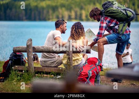 Eine Gruppe von Kaukasiern, die eine Pause in der Natur machen und auf die Karte schauen Stockfoto