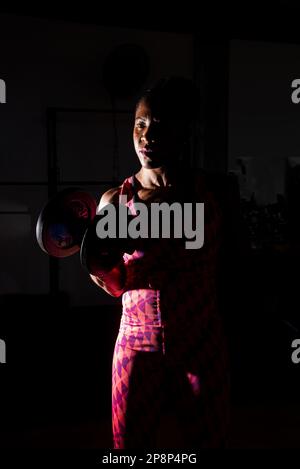 Dramatisches Porträt einer Fitness-Frau, die Armmuskeltraining macht. Fitness-Training. Stockfoto