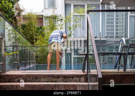 Ein Schwimmbadreiniger in einem Hotel in Ho-Chi-Minh-Stadt, Vietnam. Stockfoto