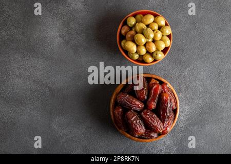 Dattel die Früchte mit grünen Oliven auf dunklem Hintergrund Stockfoto