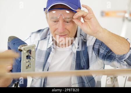 Mann schneidet Holzbrett auf Industriemaschine Stockfoto