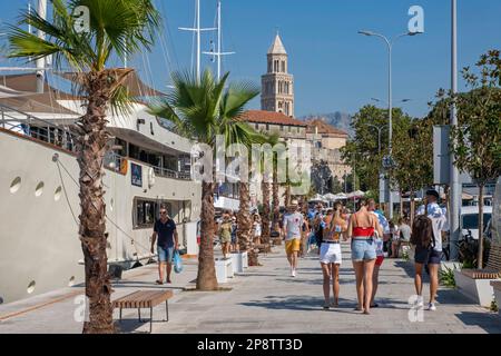 Romanischer Glockenturm der Kathedrale von St. Domnius und Touristen, die den Hafen der Stadt Split, Split-Dalmatien County, Kroatien besuchen Stockfoto