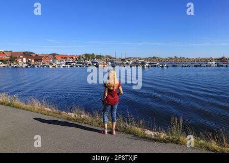 Eine Frau schaut auf den Yachthafen in Spangereid, Südnorwegen Stockfoto