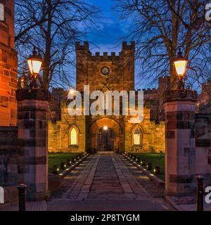 Blick von außen in der Abenddämmerung auf das Gatehouse zum Durham Castle, das unter klarem Himmel im Frühling beleuchtet wird, Stadt durham, County Durham, England, Großbritannien Stockfoto