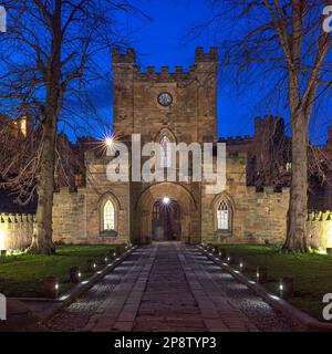 Blick von außen in der Abenddämmerung auf das Gatehouse zum Durham Castle, das unter klarem Himmel im Frühling beleuchtet wird, Stadt durham, County Durham, England, Großbritannien Stockfoto