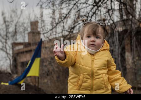 Kleines Mädchen vor den Verteidigungsstrukturen der ukrainischen Armee. Krieg in der Ukraine. Kinder- und Kriegskonzept. Unterstützung für die Ukraine. Beenden Sie den Krieg. Humanitär Stockfoto