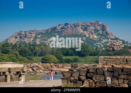 Blick auf den Anjaneyadri-Tempel auf der anderen Seite des Tungabhadra-Flusses in Hampi. Dieser Ort soll der Geburtsort von Lord Hanumana sein. Hampi ist eine UNESCO-Welt Stockfoto