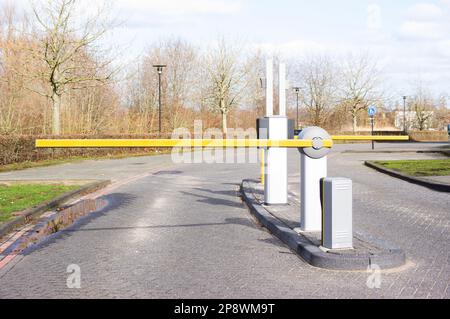 Moderne gelbe Schranke, die auf einem Parkplatz geschlossen ist Stockfoto