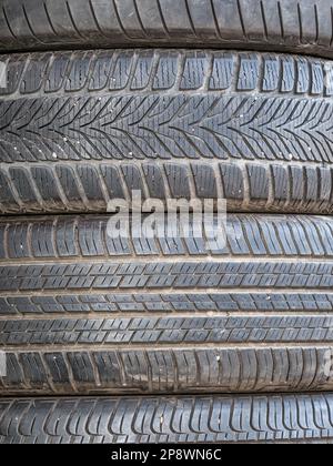 Gebrauchte Autoreifen in Pfählen gestapelt.abgenutzte Gummireifen. Stockfoto