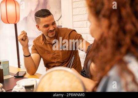 Lustige Begegnung mit jungen Männern und Frauen, Unterhaltung in einem Restaurant, Lebensstil mit sozialen Beziehungen Stockfoto