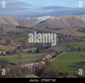 Mit den Howgills hinter einem Avanti West Coast Alstom Pendolino Zug überquerte das Docker Viadukt an der Westküste in der Landschaft von Cumbrien Stockfoto