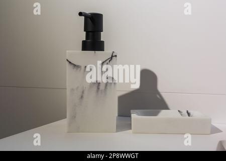 Seifen- und Shampoospender in der Nähe von keramischen Wasser Waschbecken mit Wasserhahn in teuren loft Bad tippen Stockfoto