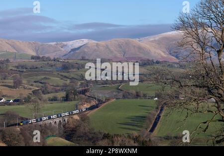 Mit den Howgills hinter einem Avanti West Coast Alstom Pendolino Zug überquerte das Docker Viadukt an der Westküste in der Landschaft von Cumbrien Stockfoto