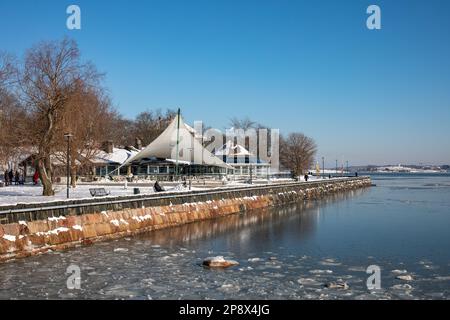 Café Ursula am Ufer an einem sonnigen Wintertag im finnischen Stadtteil Kaivopuisto im teilweise gefrorenen Meer Stockfoto