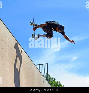 ST NEOTS, CAMBRIDGESHIRE, ENGLAND - 03. JULI 2022: Skateboarder führt Grabstunt auf der Vert Rampe durch. Stockfoto