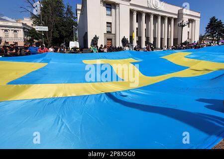 Tatarisch-Krim-Flagge. Krim ist die Ukraine. Patrioten halten große blaue Flagge mit gelbem tanga-Emblem in der Nähe des ukrainischen parlaments. Russlands Krieg gegen Ukra Stockfoto