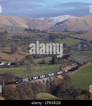 Mit den Howgills hinter einem Avanti West Coast Alstom Pendolino Zug überquerte das Docker Viadukt an der Westküste in der Landschaft von Cumbrien Stockfoto