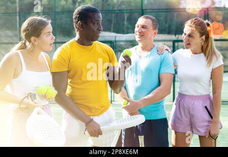 Vier Padel-Tennisspieler diskutieren etwas Stockfoto