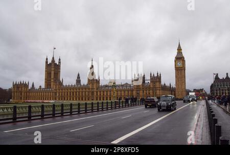 London, Großbritannien. 3. Januar 2023 Ein schwarzes Taxi fährt an den Houses of Parliament und Big Ben auf der Westminster Bridge vorbei. Stockfoto