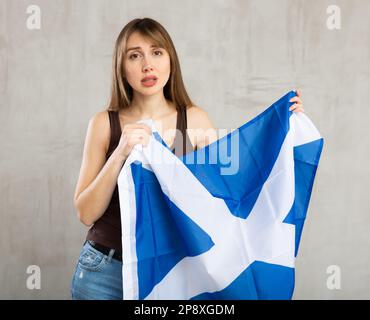 Junge traurige Frau mit schottischer Flagge Stockfoto