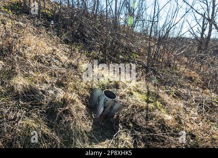 Eine nicht explodierte Rakete ragt aus dem Boden im Dorf Bogorodichne hervor. Bohorodichne ist eines der vielen Dörfer in der Oblast Donezk, die von den Russen zerstört wurden. Im Frühjahr wurden hier weiterhin Feindseligkeiten ausgeübt, und das Dorf war vom Sommer bis zum 11. September 2022 besetzt. Während dieser Zeit wurde es vollständig zerstört - kein einziges intaktes Gebäude blieb erhalten. Jetzt ist es ein Geisterdorf. Das einzige, was von den Russen zurückgelassen wurde, sind Ruinen und Berge von Müll. Es ist bekannt, dass die Eindringlinge in einem lokalen Kloster lebten. Der Feind schlug auf das Kirchengebäude Stockfoto