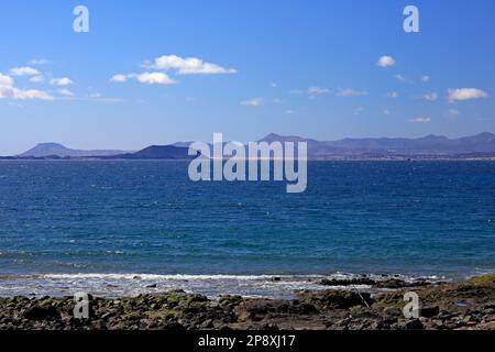 Las Coloradas Strand, Playa Blanca, Lanzarote. Blick auf die Insel Fuerteventura in der Ferne. Aufgenommen Im Februar/März 2023 Stockfoto