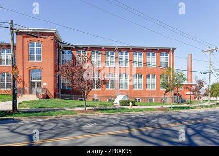 CHARLOTTE, NC-5. MÄRZ 2023: Bezirk Noda. Die Lofts in Noda Mills. Gebäude und Schornstein. Stockfoto