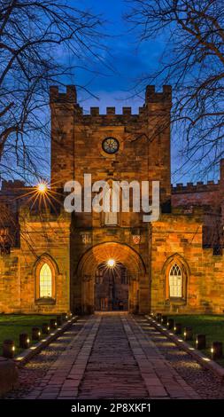 Blick von außen in der Abenddämmerung auf das Gatehouse zum Durham Castle, das unter klarem Himmel im Frühling beleuchtet wird, Stadt durham, County Durham, England, Großbritannien Stockfoto