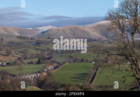 Mit den Howgills hinter einem Avanti West Coast Alstom Pendolino Zug überquerte das Docker Viadukt an der Westküste in der Landschaft von Cumbrien Stockfoto