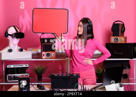 Asiatische Musiker-Werbetafeln, Sprechblase im Studio, zeigt isolierte Textnachrichten aus Pappe. Junger dj-Darsteller mit Plakatvorlage mit Coyspace, Plattenspieler aus Vinyl. Stockfoto