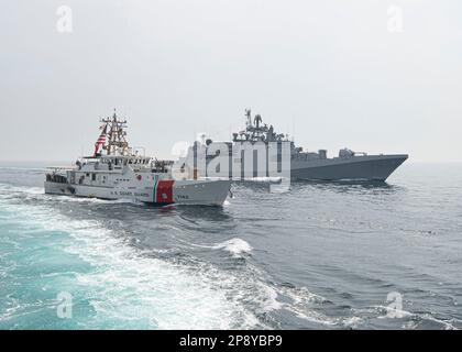 230308-N-NH267-1009 ARABISCHER GOLF (8. MÄRZ 2023) USA Küstenwache USCGC Robert Goldman (WPC 1142) und Indian Navy Fregatte INS Trikand (F51) segeln im Arabischen Golf, 8. März 2023, während der International Maritime Exercise 2023. IMX/CE 2023 ist die größte multinationale Ausbildungsveranstaltung im Nahen Osten, an der 7.000 Mitarbeiter aus mehr als 50 Nationen und internationalen Organisationen teilnehmen, die sich für die Erhaltung der auf Regeln beruhenden internationalen Ordnung und die Stärkung der regionalen Zusammenarbeit im Bereich der maritimen Sicherheit einsetzen. (USA Marinebild von Mass Communication Specialist 2. Class Elliot Schaudt) Stockfoto