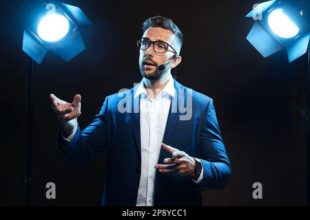 Motivationslautsprecher mit Headset, das auf der Bühne läuft Stockfoto